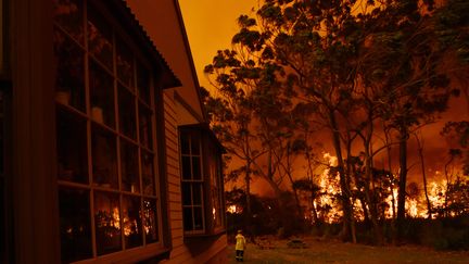 Des&nbsp;pompiers&nbsp;et des agents&nbsp;du service des parcs nationaux et de la faune sauvage (NPWS) combattent un feu aux abords du&nbsp;lac Tabourie, sur la côté sud, le 5 décembre 2019. (STRINGER / REUTERS)