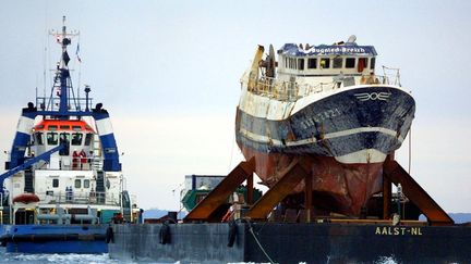 L'épave du "Bugaled Breizh" est remorquée jusqu'au port de Brest, dans le Finistère, le 13 juillet 2004. (FRED TANNEAU / AFP)