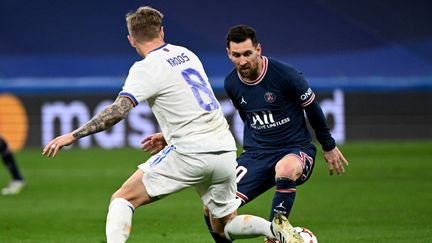 L'attaquant argentin du PSG Lionel Messi et le milieu de terrain allemand du Real Madrid Toni Kroos lors du huitième de finale de l'UEFA Champions League entre le Real Madrid CF et le Paris Saint-Germain au stade Santiago Bernabeu à Madrid, le 9 mars 2022. (GABRIEL BOUYS / AFP)