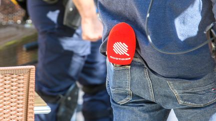 Un journaliste de "Quotidien" tient son micro dans sa poche arrière, le 8 juin 2021, lors d'une visite d'Emmanuel Macron dans la Drôme. (NICOLAS GUYONNET / HANS LUCAS / AFP)