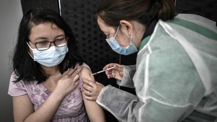 Une patiente reçoit une dose du vaccin contre le Covid-19&nbsp;Pfizer-BioNTech&nbsp;au centre de vaccination éphemère de l'Orangerie à Versailles (Yvelines), le 29 mai 2021. (STEPHANE DE SAKUTIN / AFP)