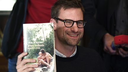 Nicolas Mathieu pose avec son roman, après avoir reçu le prix Goncourt 2018, le 7 novembre 2018. (ERIC FEFERBERG / AFP)