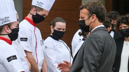 Emmanuel Macron&nbsp;en visite dans un lycée hôtelier de la Drôme, à la veille de l'ouverture des salles de restaurant, le 8 juin 2021. (PHILIPPE DESMAZES / AFP)