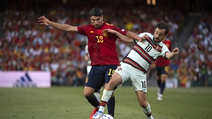 L'Espagnol Carlos Soler et le Portugais Bernardo Silva, le 2 juin 2022 à Séville. (JORGE GUERRERO / AFP)