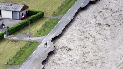 A Villelongue (Hautes-Pyren&eacute;es), la chauss&eacute;e s'est effondr&eacute;e sous le poids de l'eau provenant de la rivi&egrave;re Lanne en crue, le 19 juin 2013. (LAURENT DARD / AFP)