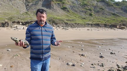 Laurent Picot, paléontologue, directeur scientifique du Paléospace, sur la plage de Villers-sur-Mer, au pied des falaises des Vaches Noires. (BORIS HALLIER / FRANCEINFO / RADIO FRANCE)