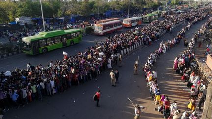 Des milliers de travailleurs migrants tentent de prendre le bus pour rejoindre leur village pendant le confinement, le 28 mars 2020 à New Delhi (Inde). (BHUVAN BAGGA / AFP)