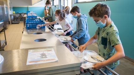 Des collégiens débarrassent leurs plateaux de cantine, le 2 juin 2020, à Beaucamps-Ligny (Nord). (JULIE SEBADELHA / HANS LUCAS / AFP)