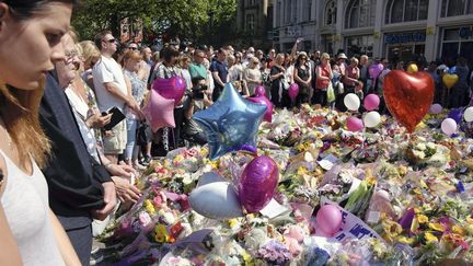 Des habitants de Manchester (Royaume-Uni) se recueillent devant un mémorial improvisé aux victimes de l'attentat, le 25 mai 2017. (SHIOMI KADOYA / YOMIURI / AFP)