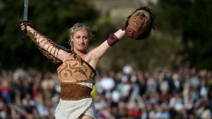 Une femme d&eacute;guis&eacute;e en gladiateur brandit une t&ecirc;te en plastique lors de c&eacute;r&eacute;monies f&ecirc;tant les 2 767 ans de Rome (Italie), le 21 avril 2014. (FILIPPO MONTEFORTE / AFP)