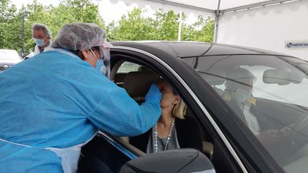 Une infirmière effectue un prélèvement auprès de passagers d'une voiture pour réaliser un test du coronavirus,&nbsp;à Bayonne (Pyrénées-Atlantiques) le 13 mai 2020. (NATHALIE BAGDASSARIAN / FRANCE-BLEU PAYS BASQUE / RADIO FRANCE)