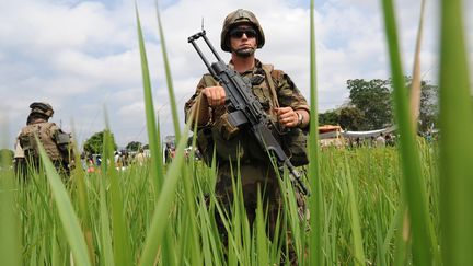 Des soldats fran&ccedil;ais montent la garde &agrave; l'a&eacute;roport de Bangui (Centrafrique), pendant une distribution de nourriture aux r&eacute;fugi&eacute;s, le 13 d&eacute;cembre 2013. (SIA KAMBOU / AFP)