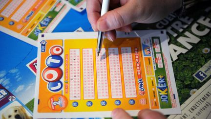 Un joueur remplit sa grille de Loto, le 12 avril 2012 &agrave; Paris.&nbsp; (FRANCK FIFE / AFP)