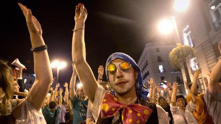 Des "indignados" espagnols respectent une minute de silence bras lev&eacute;s, le 12 mai 2012, sur la place de la Puerta del Sol &agrave; Madrid, pour l'anniversaire du mouvement.&nbsp; (JAIME REINA / AFP)