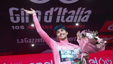 Jai Hindley sur le podium après avoir récupéré le maillot rose de leader sur le Tour d'Italie le 28 mai 2022. (LUCA BETTINI / AFP)