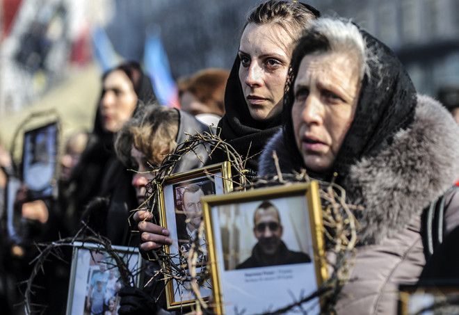 Kiev (Ukraine), 26 février 2014 : lors d'une marche commémorative, deux femmes montrent les portraits d'hommes tués dans les manifestations.
 (Bulent Kilic / AFP)