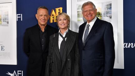 Tom Hanks (gauche) et Robin Wright (centre) jouent dans le nouveau film de Robert Zemeckis (droite), "Here : les plus belles années de notre vie", en salles le 6 novembre 2024. (VALERIE MACON / AFP)