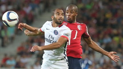 Le Parisien Lucas Moura &agrave; la lutte avec le Lillois Djibril Sidibe, lors du match entre le PSG et le Losc, le 7 ao&ucirc;t 2015. (FRANCOIS NASCIMBENI / AFP)