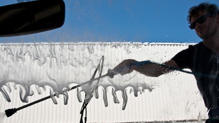 Un homme en train de laver sa voiture à une station de lavage, à Millau, dans l'Aveyron. (KAREN ASSAYAG / HANS LUCAS)