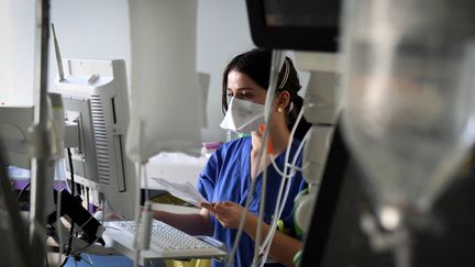 Une soignante&nbsp;s'occupe d'un patient en réanimation à l'hôpital Ambroise Paré de l'AP-HP à Boulogne-Billancourt&nbsp;(Île-de-France), le 8 mars 2021. (ALAIN JOCARD / AFP)