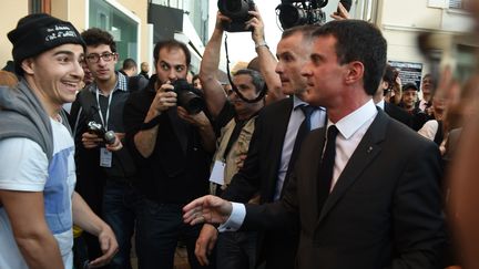 Manuel Valls face à un groupe de jeunes&nbsp;qui l'ont hué&nbsp;à Moirans (Isère), le 6 novembre &nbsp;2015. (PHILIPPE DESMAZES / AFP)