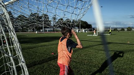 Un enfant lors d'un entraînement de foot, à Saint-Priest (Rhône) (llustration). (JEFF PACHOUD / AFP)