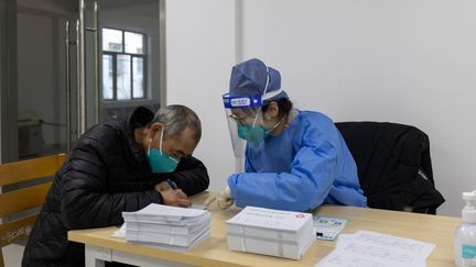 Un patient pris en charge par un médecin, le 9 janvier 2023, à Shanghai (Chine). (WANG XIANG / XINHUA / AFP)