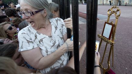 La foule mass&eacute;e devant les grilles du palais de Buckingham tente d'apercevoir l'avis de naissance du "royal baby", Londres (Royaume-Uni), le 22 juillet 2013. (NEIL HALL / REUTERS)