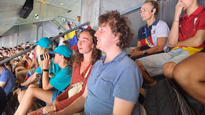 Mathys Foreau, accompagné de sa cousine Mathilde, suit une session d'athlétisme au Stade de France, le 5 août 2024, à l'occasion des Jeux olympiques. (RAPHAEL GODET / FRANCEINFO)