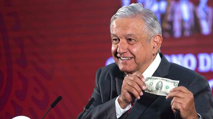 Le président mexicain Andrés Manuel López Obrador explique avoir un billet de 2 dollars&nbsp;offert par un migrant comme bouclier contre le coronavirus, le 18 mars 2020. (- / MEXICAN PRESIDENCY)