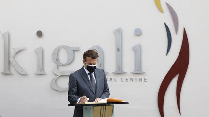 Emmanuel Macron signe le livre du souvenir lors de sa visite au mémorial du génocide des Tutsis de Kigali (Rwanda), où 250 000 victimes Tutsis sont enterrées, jeudi 27 mai 2021. (LUDOVIC MARIN / AFP)