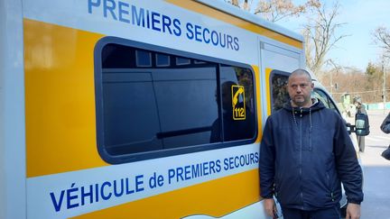 Nicolas&nbsp;Bourbouze est Français&nbsp;: il conduit une ambulance dans la ville d'Irpin, aux portes de Kiev. Il pose ici avec son véhicule, le 29 mars 2022. (GILLES GALLINARO / RADIO FRANCE)