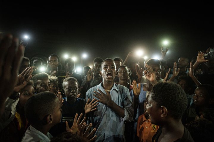 Un homme récite un poème au milieu d’un groupe de manifestants à Khartoum, au Soudan. Une photo de&nbsp;Yasuyoshi Chiba&nbsp;dans le cadre de l'exposition "L'Afrique de Chiba".&nbsp; (YASUYOSHI CHIBA / AFP)