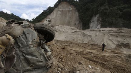 Une voiture retournée à Santa Catariana Pinula (Guatemala)&nbsp;le 10 octobre. Un signe du glissement de terrain qui a recouvert&nbsp;la banlieue de Guatemala City quelques jours plus tôt. Des dizaines de maisons ont été ensevelies. (JOSUE DECAVELE / REUTERS)