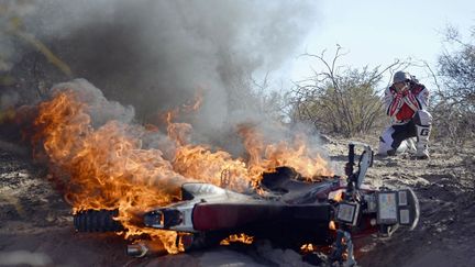 Le pilote portugais Paulo Goncalves se d&eacute;sole devant sa Honda en flammes lors de la 5e &eacute;tape du rallye Dakar entre Chilecito et Tucuman (Argentine), le 9 janvier 2014. (REUTERS )