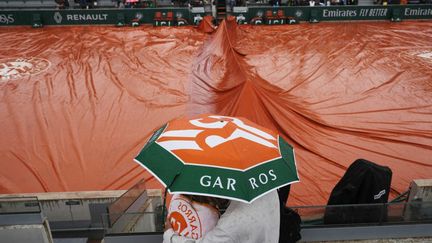 Le temps fait grise mine à Roland-Garros... La pluie a grandement perturbé la première semaine, pour placer les bâches au centre du jeu. (DIMITAR DILKOFF / AFP)