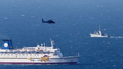 Un navire militaire isra&eacute;lien (D) et un h&eacute;licopt&egrave;re de l'arm&eacute;e isra&eacute;lienne &agrave; la recherche des d&eacute;bris du drone abattu au large de Ha&iuml;fa (Isra&euml;l), le 25 avril 2013. (JACK GUEZ / AFP)