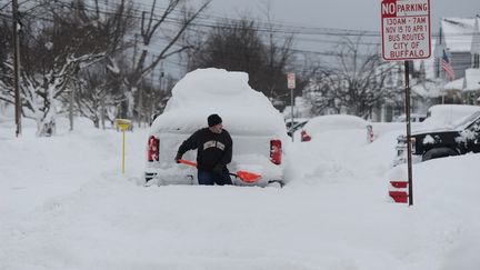 Un homme essaie de déterrer son camion enneigé, le 26 décembre 2022, à Buffalo (New York). (JOHN NORMILE / GETTY IMAGES NORTH AMERICA / AFP)