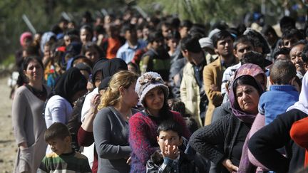 Des migrants font la queue pour recevoir de la nourriture à l'extérieur du centre d'enregistrement, appelé "hotspot", situé sur l'île grecque de Samos (LEFTERIS PITARAKIS / AP / SIPA)