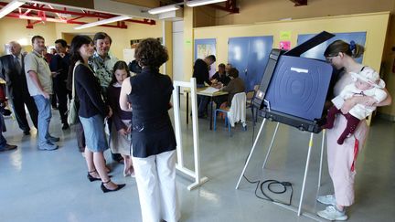 Les électeurs de Vaureal (Issy-les-Moulineaux) ont voté pour le premier tour la présidentielle 2022 sur des machines à&nbsp;voter. (PIERRE VERDY / AFP)