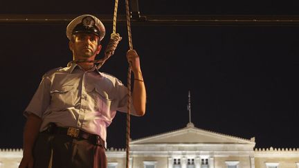 Un officier de police simule sa pendaison devant le Parlement &agrave; Ath&egrave;nes (Gr&egrave;ce) pour protester contre les r&eacute;ductions budg&eacute;taires, le 6 septembre 2012. (JOHN KOLESIDIS / REUTERS)