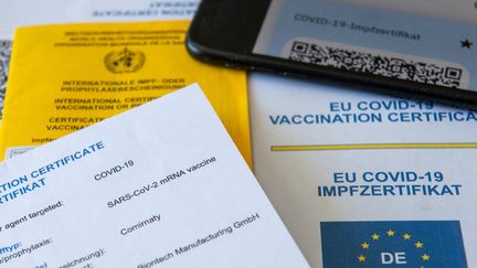 Un&nbsp;"certificat&nbsp;Covid" de l'Union européenne, en version papier et numérique, à&nbsp;Augsbourg, en Allemagne, le 14 juin 2021. (STEFAN PUCHNER / DPA / AFP)