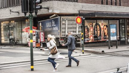 Des passants s'enfuient alors qu'un camion s'est encastré dans le mur d'un centre commercial sur&nbsp;Drottninggatan, au centre de Stockholm, le 7 avril 2017.&nbsp; (TOMAS ONEBORG/SVD / TT NEWS AGENCY / AFP)