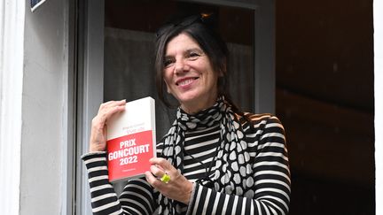 Brigitte Giraud tient son roman "Vivre Vite" (Flammarion) à la fenêtre du restaurant Drouant après avoir reçu le prestigieux prix Goncourt, à Paris, le 3 novembre 2022. (BERTRAND GUAY / AFP)