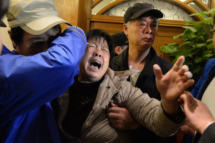 Cris et sanglots dans un h&ocirc;tel de P&eacute;kin (Chine) o&ugrave; les familles ont appris la mort de leurs proches. (GOH CHAI HIN / AFP)