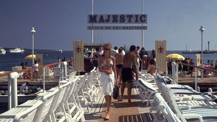 Des vacanciers sur la plage de l'h&ocirc;tel Majestic &agrave; Canne le 27 juin 2014. (NEIL SETCHFIELD / THE ART ARCHIVE / AFP)