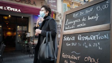 Une femme passe devant un restaurant, à Nice (Alpes-Maritimes), le 22 octobre 2020. (ARIE BOTBOL / HANS LUCAS / AFP)