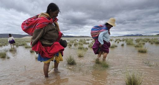 Paysannes marchant dans un champ d'orge inondé par des crues à Masaya (60 km à l'ouest de la Paz) le 9 mars 2012 (AFP - Aizar Raldes)