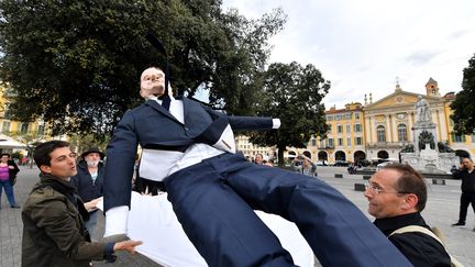 Des militants de La France Insoumise avec un "paillassou" (ici à l'effigie de Macron), à Nice le 4 mai en prélude à "La Fête à Macron" organisée le lendemain à Paris. (YANN COATSALIOU / AFP)