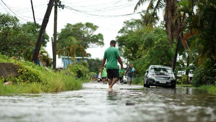 Des résidents pataugent dans les rues inondées de Suva, la capitale des Fidji, le 16 décembre 2020. (LEON LORD / AFP)